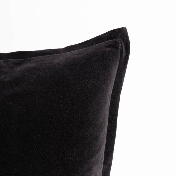 A corner image of a velvet long lumbar cushion, in a bold, deep shade of black by Eadie Lifestyle