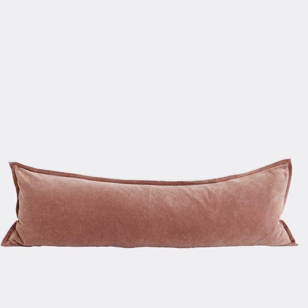 A corner image of a velvet long lumbar cushion, in a muted rose pink by Eadie Lifestyle