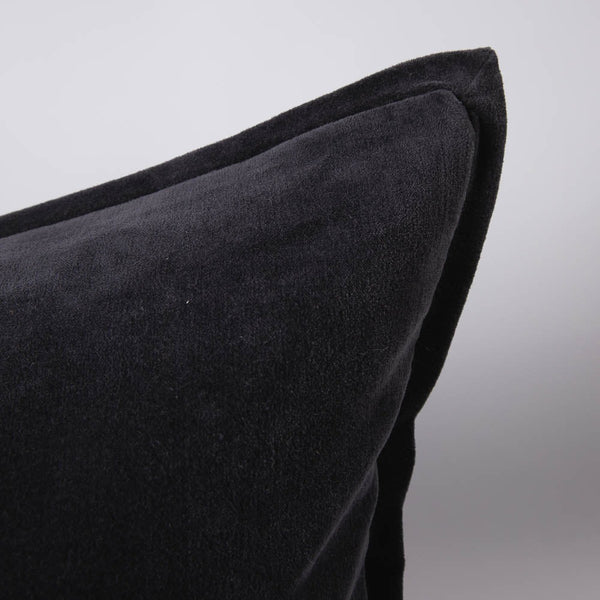 A corner image of a velvet long lumbar cushion, in a sophisticated midnight blue shade by Eadie Lifestyle