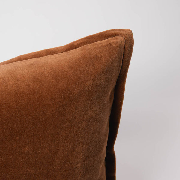 A corner image of a velvet long lumbar cushion, in a warm red-brown tone by Eadie Lifestyle