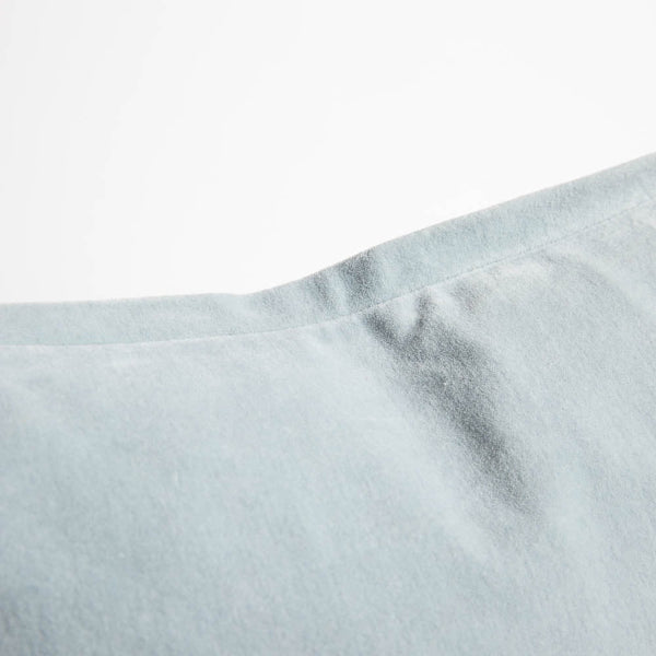 A detail image of a velvet long lumbar cushion, in a pastel pale blue by Eadie Lifestyle