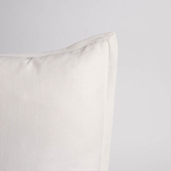 A corner image of a velvet long lumbar cushion, in a delicately creamy shade of white by Eadie Lifestyle