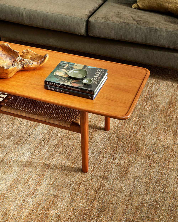 A close up of a coffee table on a warm beige textural floor rug with contrasting handmade fibres, by Baya.