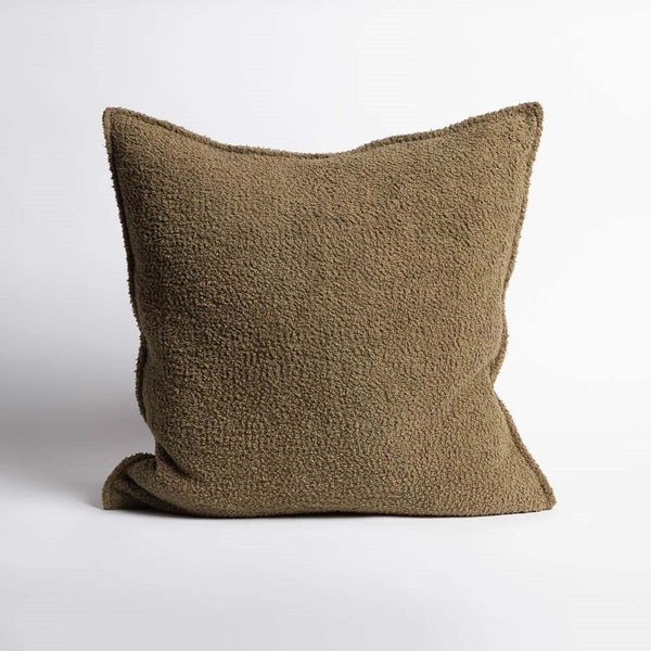 A full image of a subtly textured boucle cushion in an on-trend shade of moss green, by Eadie Lifestyle