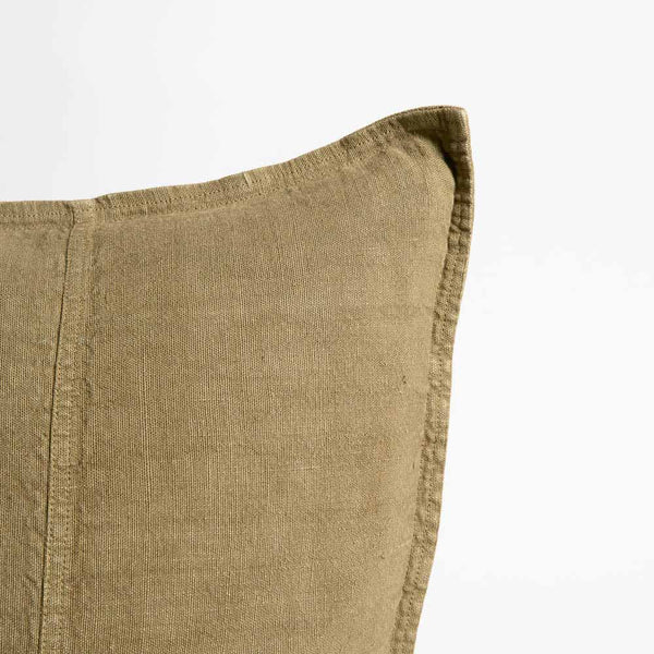 The corner of a linen cushion, with a delicate flange edge and hem detailing, in an on-trend olive colour.