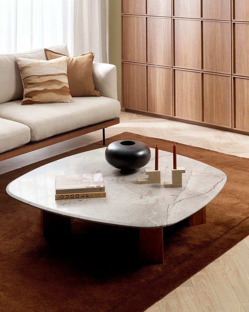 A coffee table on top of a stunning chocolate brown floor rug with cut pile frame detailing around the border.