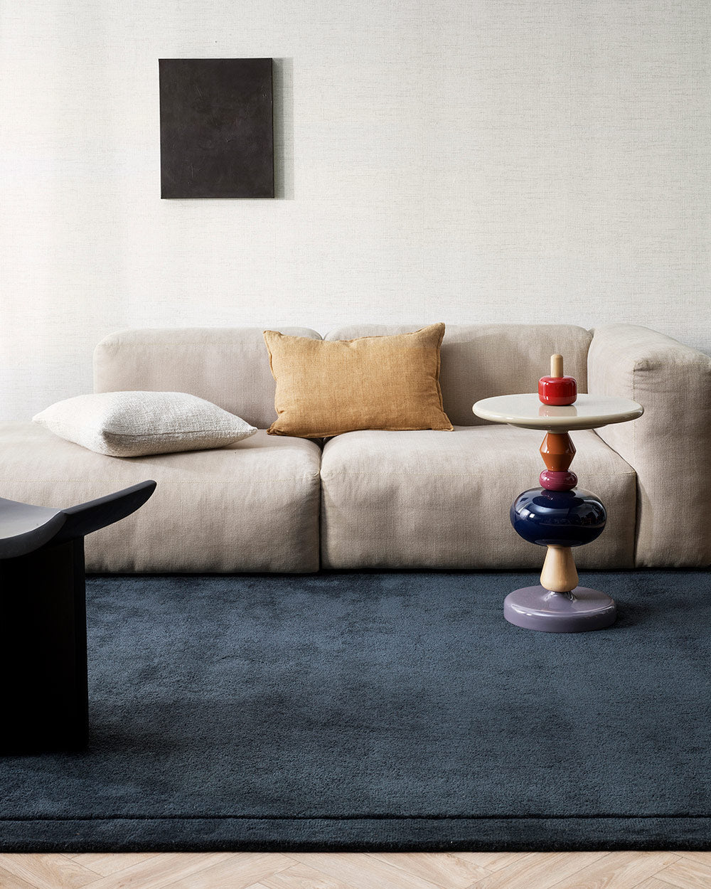 A cool toned living room with a statement deep midnight blue cut pile floor rug in 100% New Zealand wool.