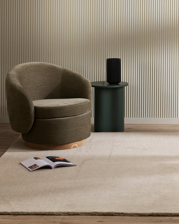 A minimalist sitting area with a soft beige grey floor rug in 100% wool.
