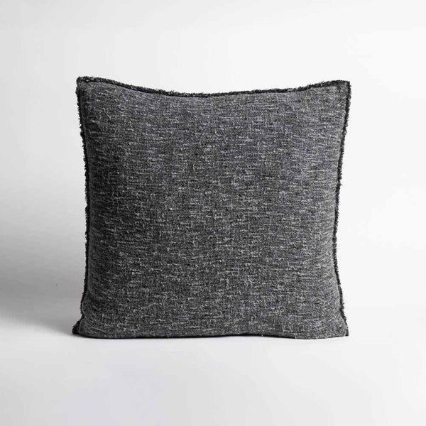 A textured cotton midnight blue throw pillow with softly fringed edges.