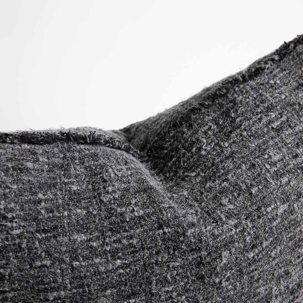 A detail view of the edge of the Sora cushion, showing the softly fringed hem and the highly textured cotton of the fabric.