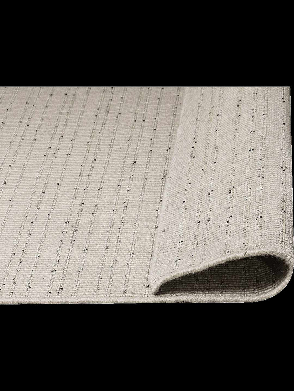 The Tribe Home Fritz floor rug , in colour ivory, seen from above - close up - with the end folded up so underneath is revealed