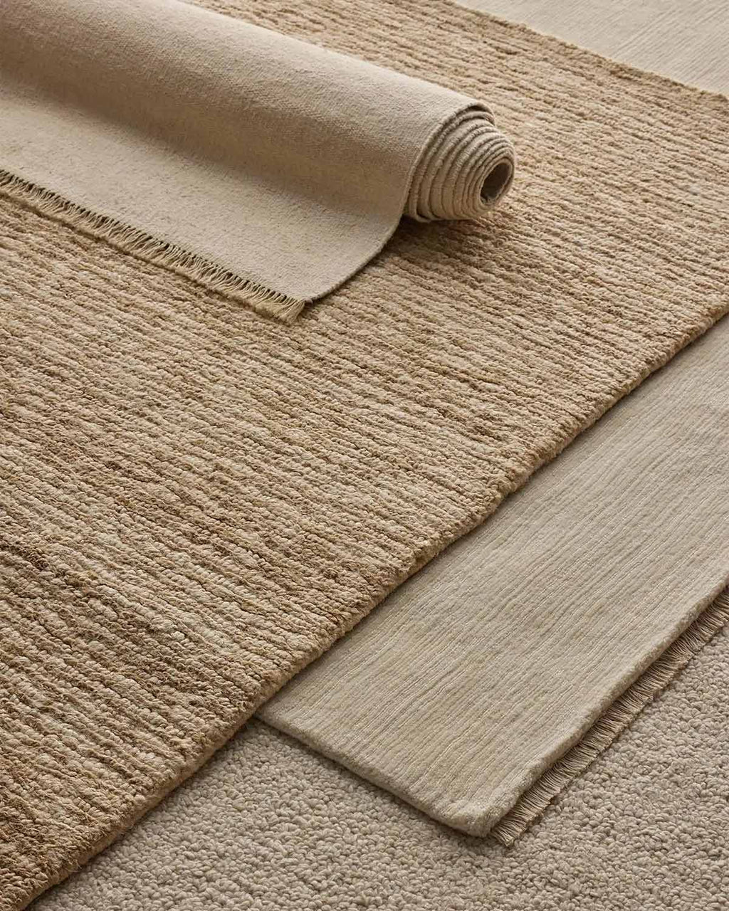 An assortment of floor rugs in shades of cream, by Weave Home.