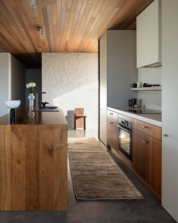 Baya NZ Anchorage floor runner in Sand Dune situated in a warm, modern kitchen.