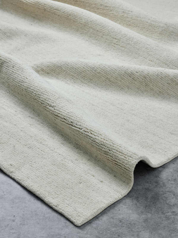 A luxurious, textural cut pile floor rug in 100% NZ wool with shades of ivory silver made by Tribe Home.