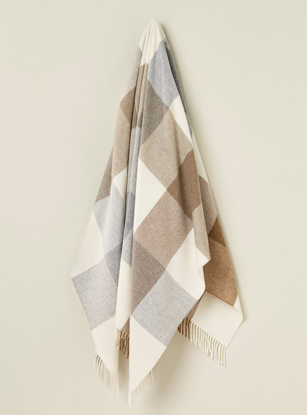 A hanging throw in 100% merino wool with a block check pattern in neutral browns and creams.