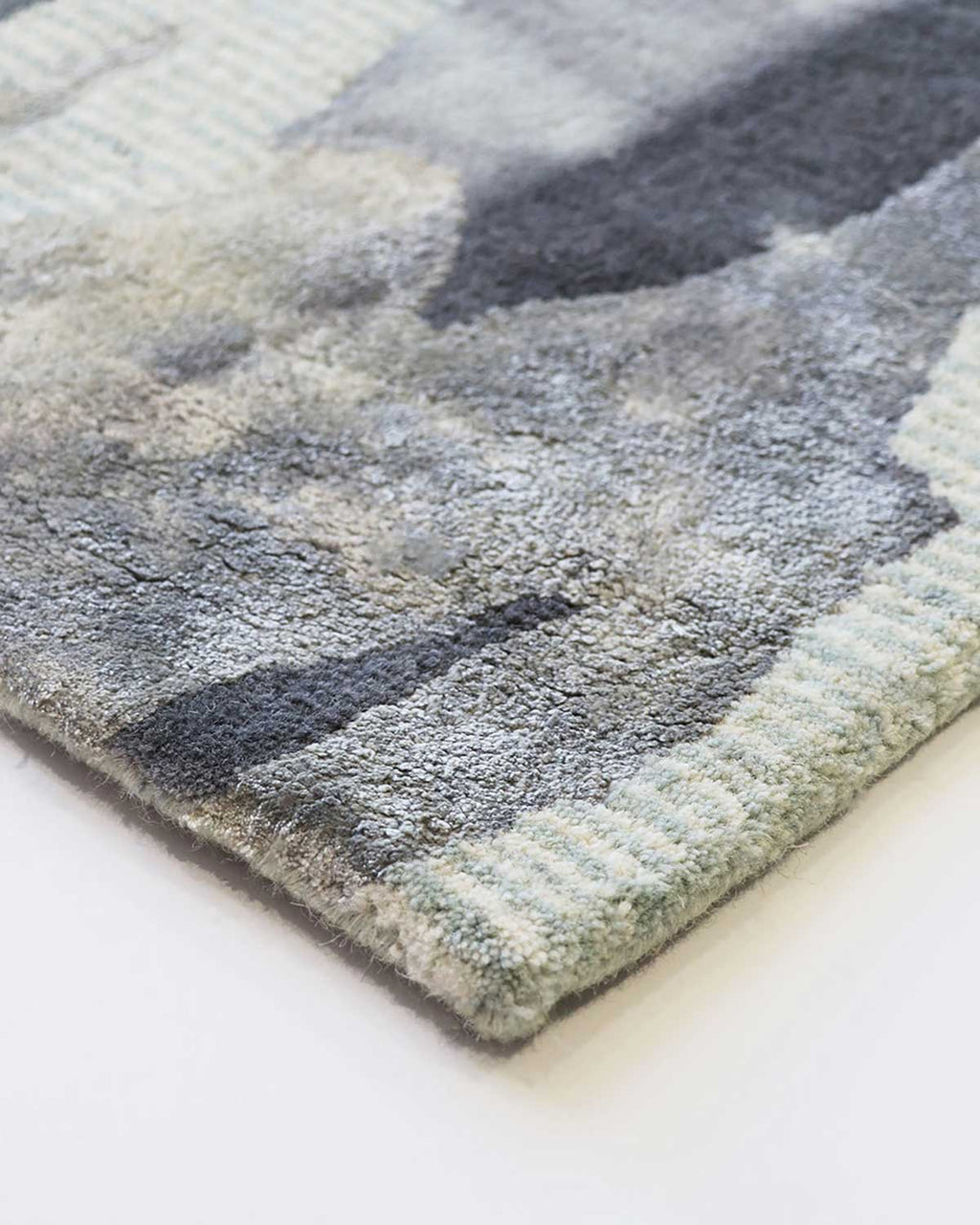 Close up of Baya NZ's Cape Brett rug, handtufted with cool greys and blues.
