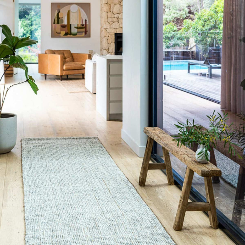 A hallway with a stylish textured floor runner woven in boucle style with a blend of cream wool and natural brown jute.