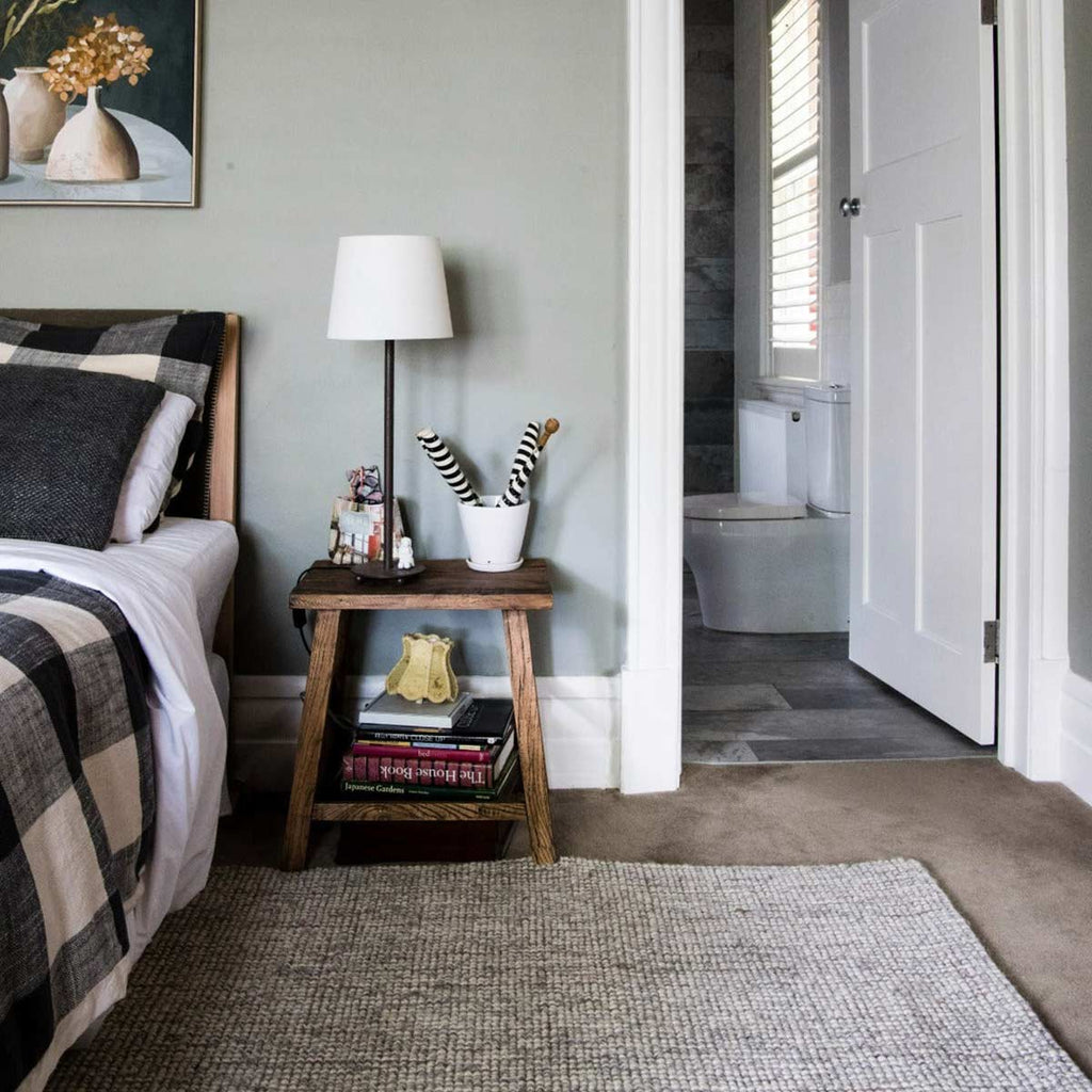 A modern style bedroom with a textural floor rug in shades of cream and brown, made with wool and jute.