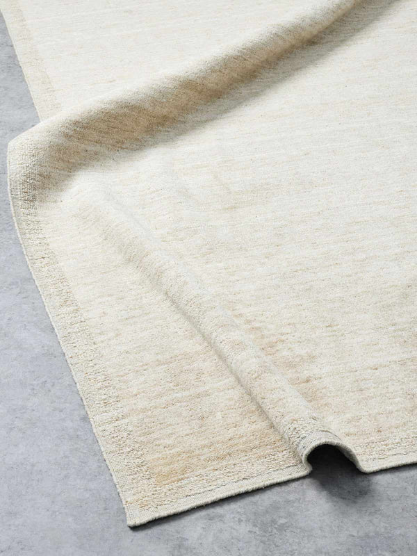 A creamy ivory floor rug, handmade with 100% New Zealand wool by Tribe Home
