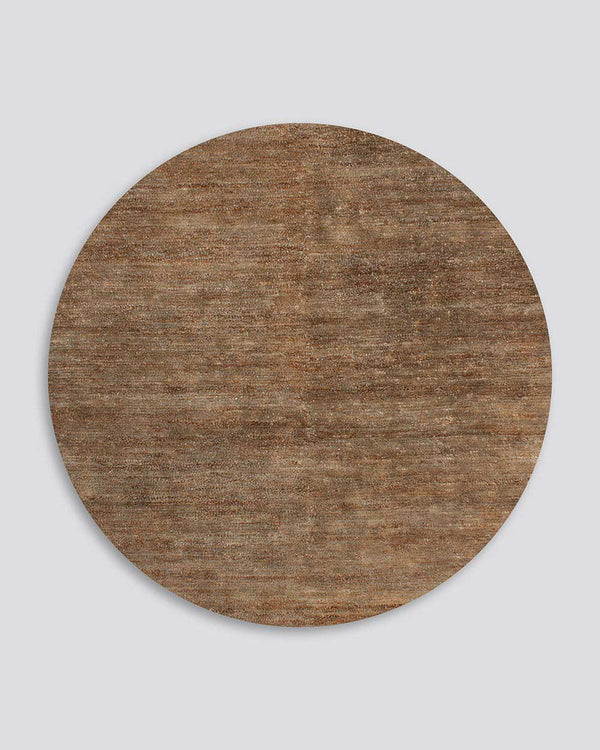 A full image of the Fairbanks floor rug in Round, an effortlessly luxurious bamboo silk and jute blend. The warm brown of the jute blends with the honey tones of the silk in a beautiful medley.