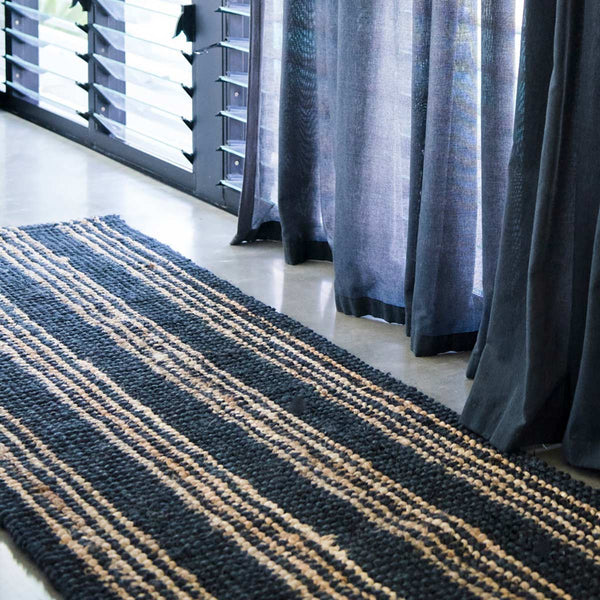A black and brown striped handwoven hallway runner made of natural jute fibres.