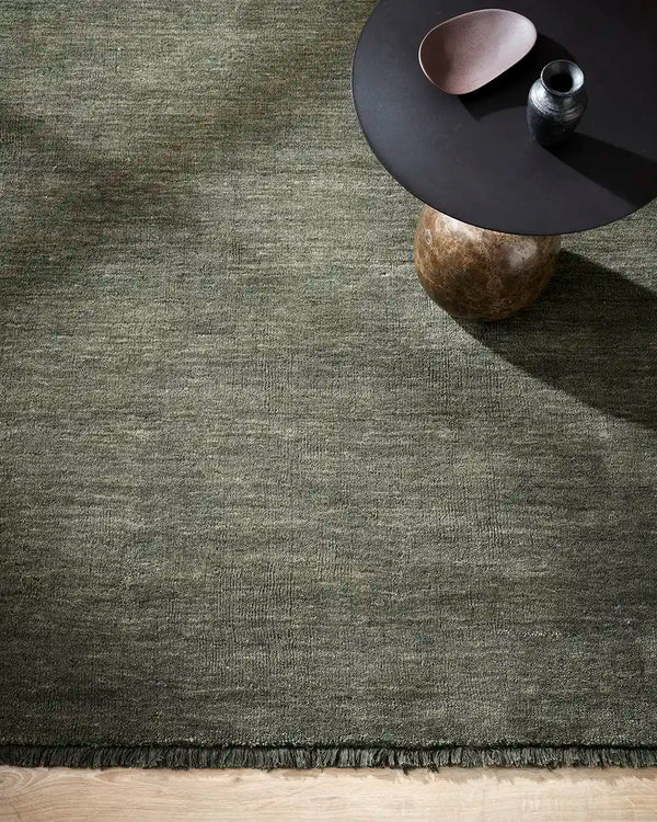 The Baya Sandringham wool rug in colour 'Forest' green with tasseled fringe