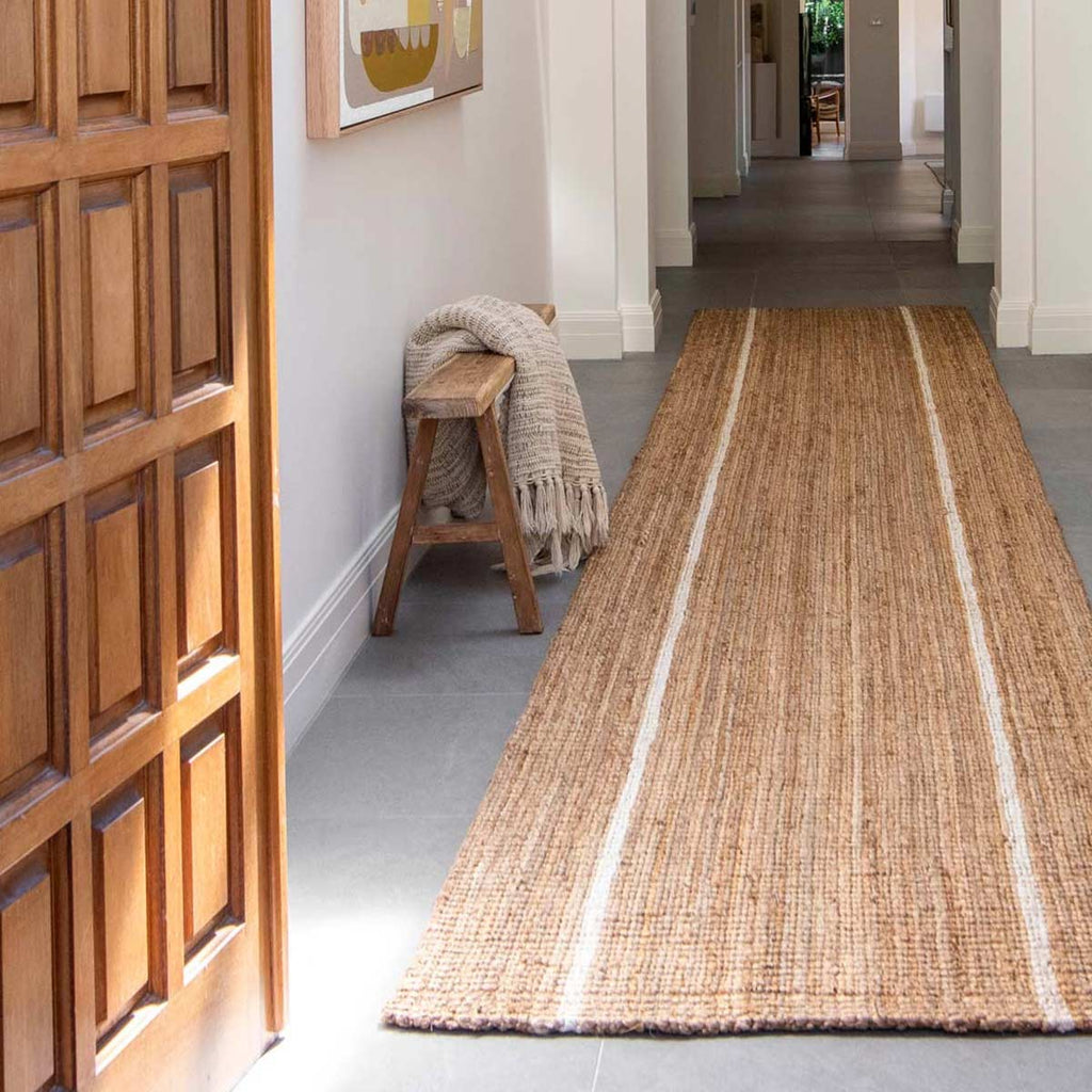 A hallway runner in natural jute fibres with two white stripes.