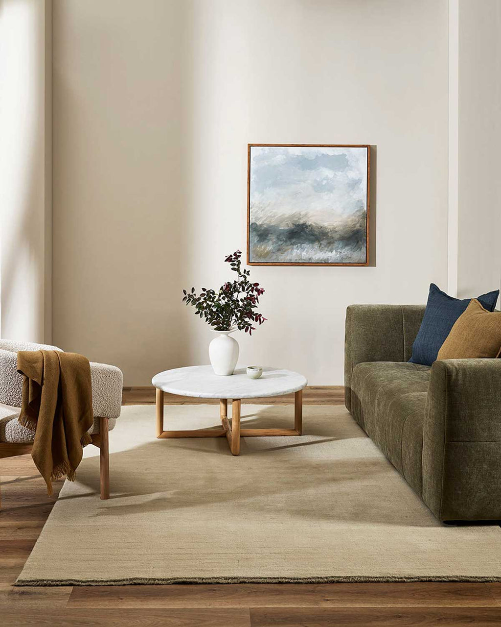 A warm beige floor rug adorns the floor of this homely soft sitting room.