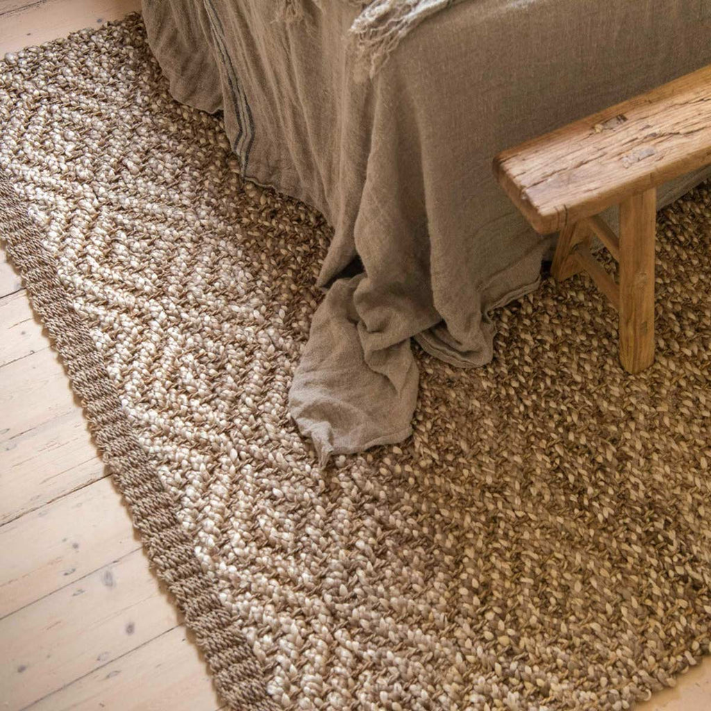 A floor rug made with natural jute fibres in a boucle style diamond pattern.