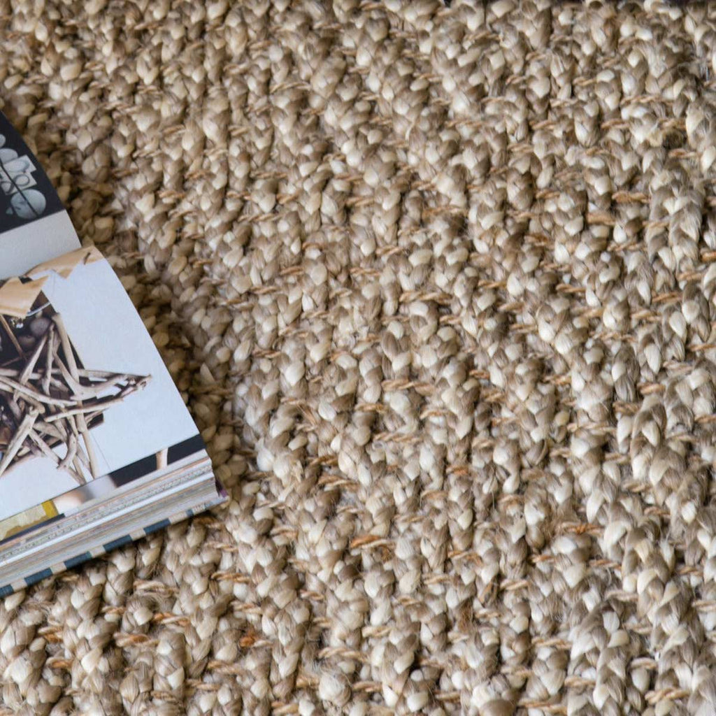 A close image of a diamond patterned boucle style natural jute floor rug.