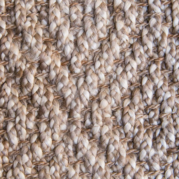 A detailed view of the weave of a diamond patterned boucle natural brown jute floor rug.