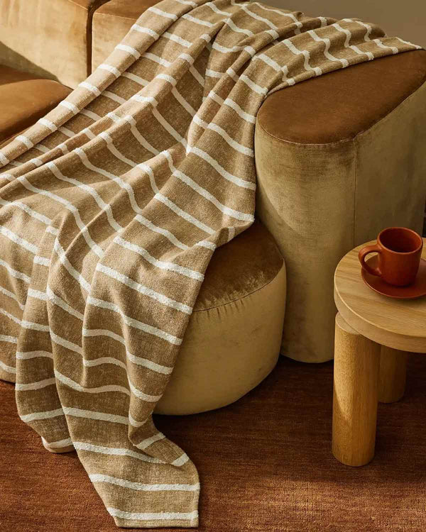 Soft brown striped throw blanket by Weave Home on a modern couch.
