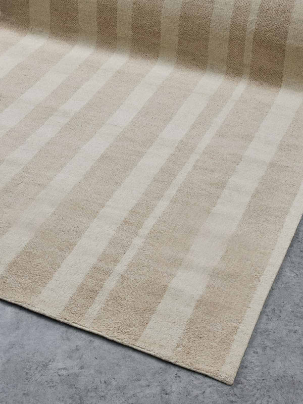 A striped taupe and ivory floor rug,  handloomed with 100% NZ wool by Tribe Home