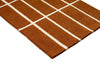 Corner close up of a Marimekko NZ wool geometric patterned rug in an on-trend rusty brown