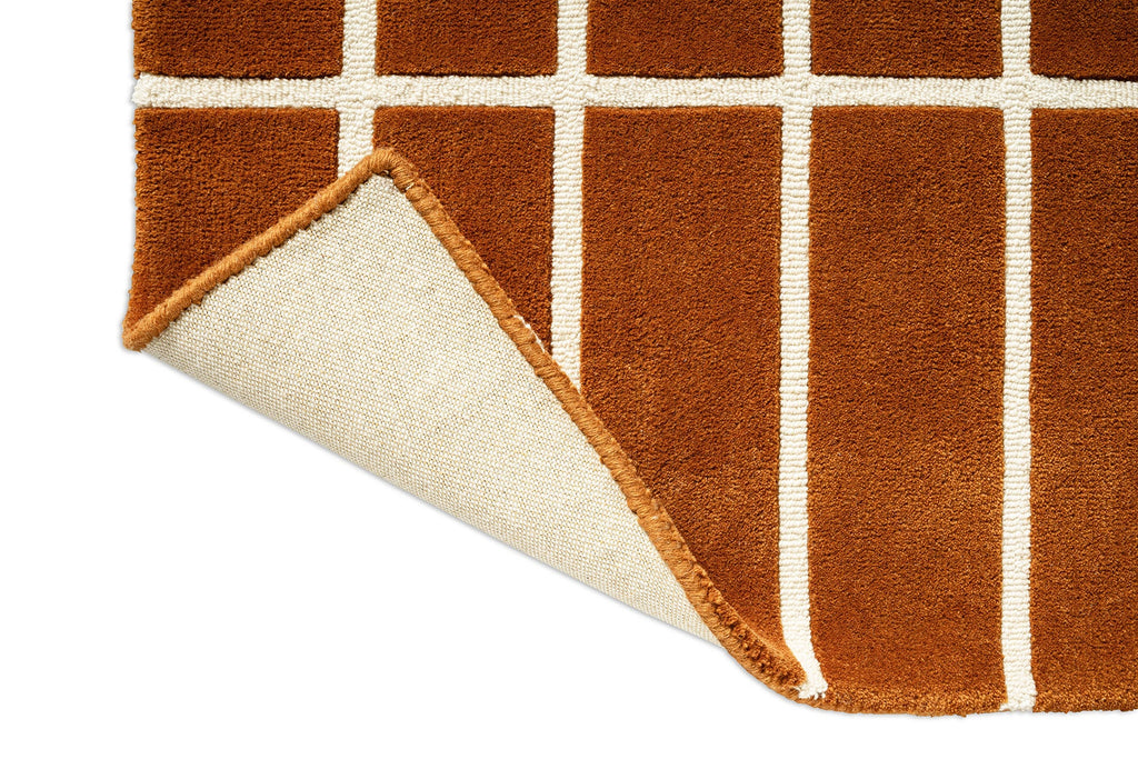 Corner close up of a Marimekko NZ wool grid patterned rug with corener folded up to show the backing