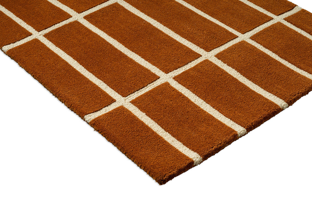 Corner close up of a grid patterned rug by Marimekko in a brick colour
