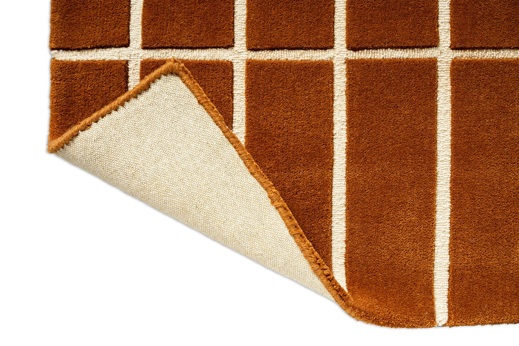 Corner close up of a Marimekko NZ wool rust patterned rug