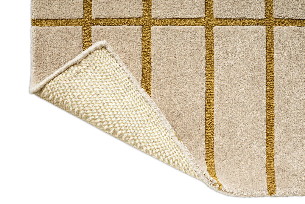 Corner of a Marimekko NZ wool beige runner rug with gold grid pattern, showing the backing