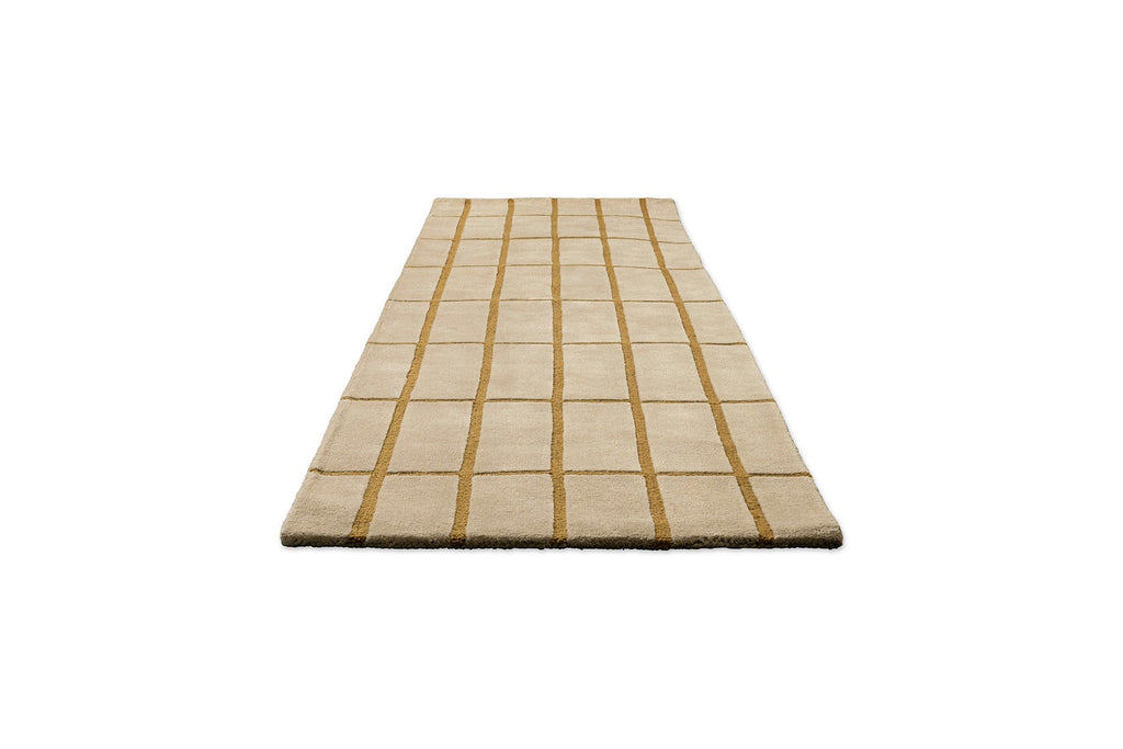 Perspective view of a Marimekko NZ wool beige runner rug with gold grid pattern 