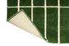 Close up corner view of a green geometric Marimekko NZ wool rug  with corner folded up