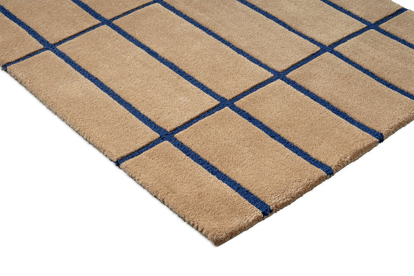  Close up of a Marimekko NZ wool runner rug with blue grid pattern on a beige  background