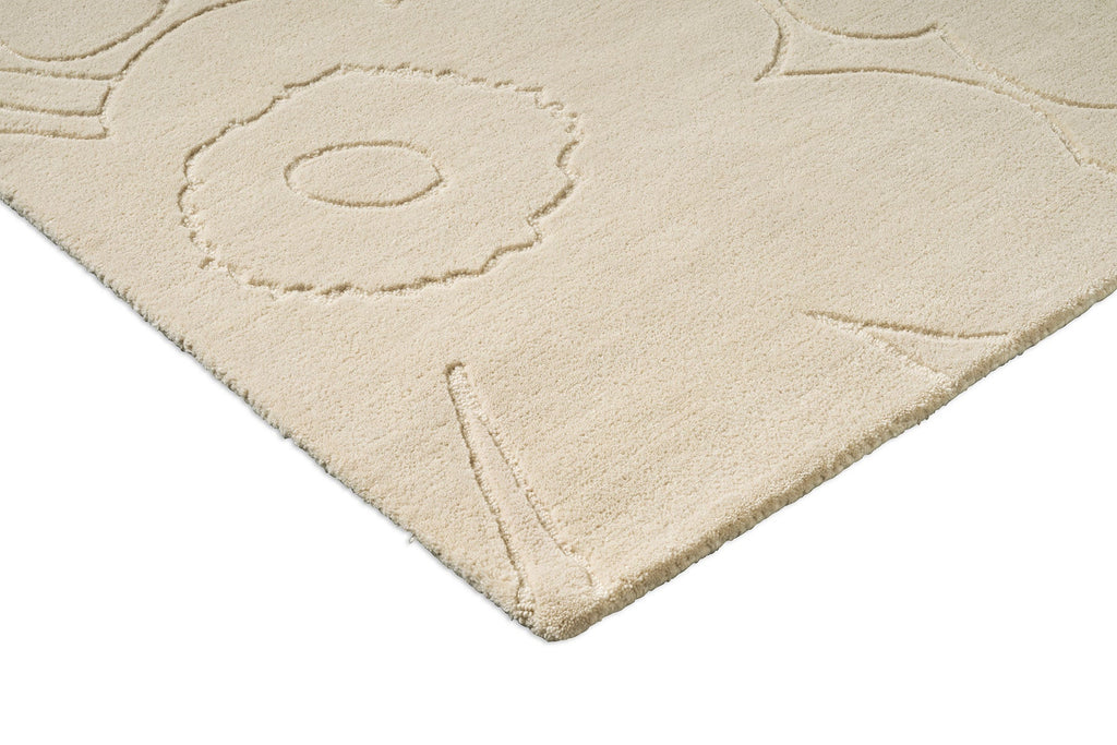 Corner close up of a creamy white Marimekko NZ wool rug with a subtle floral unikko graphic