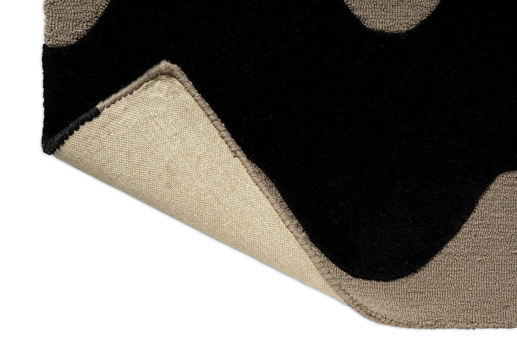 Extreme close up of a Marimekko NZ wool Rug with black wavy pattern on beige showing the backing