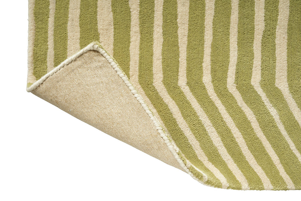 Close-up corner of a Marimekko green and beige offbeat geometric striped rug showing the backiing