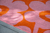 Close-up of a Marimekko pink and orange floral outdoor patterned rug.