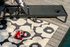 Black lounge chair on a Marimekko patterned rug by a poolside
