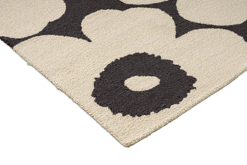 Close-up of a Marimekko outdoor rug with a Unikko floral pattern featuring beige flowers and black centers.