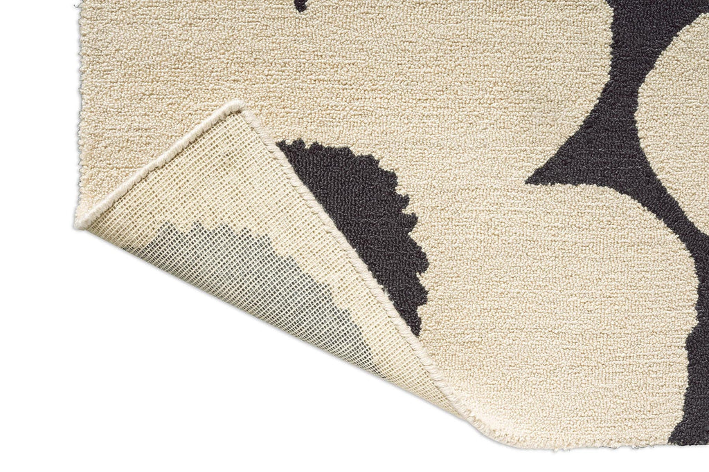 Close-up of a Marimekko outdoor rug with Unikko black graphic design on a beige background