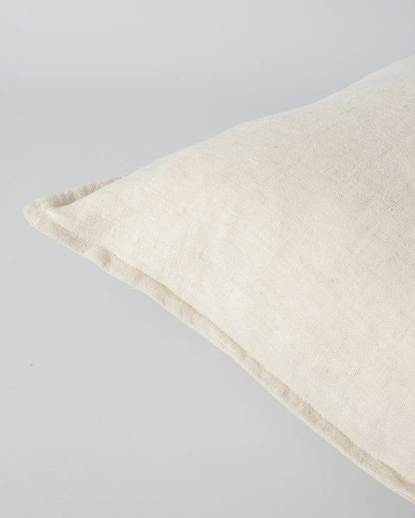 Corner detail showing flange of a cream linen cushion by Baya, the Cassia colour 'Almond'