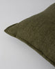 Close up of the Baya Flaxmill linen cushion with a flange edge, in colour moss green